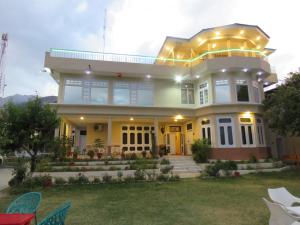 Una gran casa amarilla con luces encima. en Legendary Hotel Chitral, en Chitral