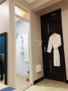 - un peignoir suspendu à une porte dans la salle de bains dans l'établissement Diary Hotel, à Dar es Salaam