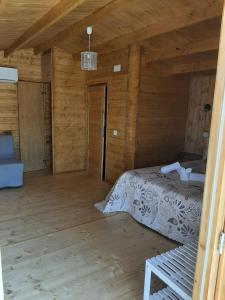 Dormitorio de una cabaña de madera con cama en Quinta do Pinheiro, en Grândola
