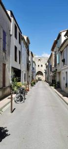 an empty street with a bike parked in the middle at La flemme en rose in Aigues-Mortes