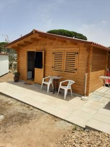 una cabaña con mesa y sillas frente a ella en Quinta do Pinheiro, en Grândola