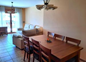 a living room with a table and a couch at Planta baja con jardín en Llívia in Llivia