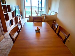 a large wooden table with chairs in a living room at Planta baja con jardín en Llívia in Llivia