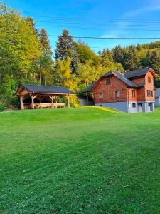 a barn with a large green field in front of a house at DOM ZORA in Brenna
