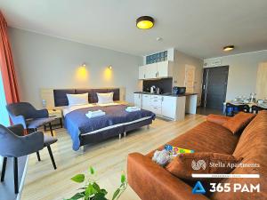 1 dormitorio con 1 cama y 1 sofá en una habitación en Dominikana Studio Apartamenty - 365PAM, en Sianożęty