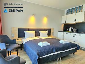 1 dormitorio con 1 cama con 2 toallas en Dominikana Studio Apartamenty - 365PAM, en Sianożęty
