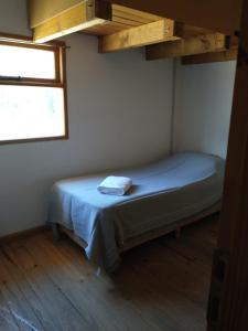 a small bed in a room with a window at Departamento en Junin de Los Andes in Junín de los Andes