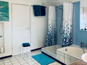 a bathroom with a tub and a toilet and a sink at Ferienapartment Kastanje in Groß Ippener