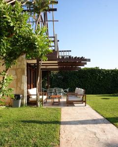 a deck with chairs and a table in a yard at Laguava Resort in Ar Rumaylah