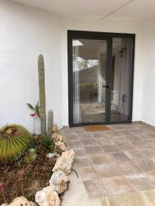 una puerta corredera de cristal de una casa con un cactus en Casa con vista y jardín, a 20' de la playa en Sant Cebrià de Vallalta