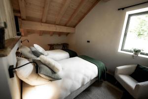 two beds in a room with a couch and a window at La Loge de la Dolarde - Chambre Sud in Prémanon