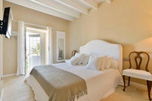 1 dormitorio con 1 cama blanca y 1 silla en Dalt Vila House en Ibiza