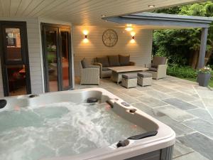 a jacuzzi tub on the patio of a house at Wolfen Mill in Chipping