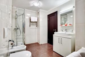 a white bathroom with a sink and a shower at Bratislava Hotel Kyiv in Kyiv