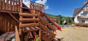 a wooden playground with a slide at Górski Pałacyk Kompleks obiektów in Kościelisko