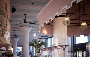 a restaurant with white columns and ceiling lights at Hotel Riviera in Moss