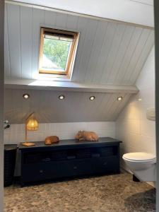 La salle de bains est pourvue de toilettes et d'une fenêtre. dans l'établissement Woonboerderij Markelo, à Markelo