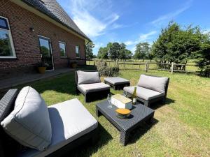 a backyard with couches and a table and sidx sidx sidx at Woonboerderij Markelo in Markelo