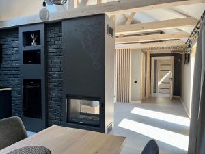 a living room with a fireplace and a brick wall at Clockhouse Cottage in Saulkrasti