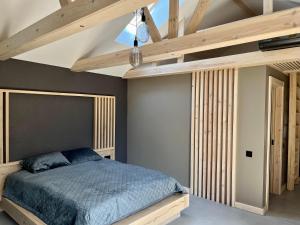 a bedroom with a bed and a wooden ceiling at Clockhouse Cottage in Saulkrasti