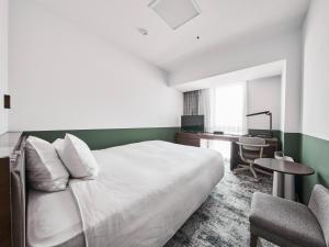 a bedroom with a bed and a desk and a chair at Richmond Hotel Fukuyama Ekimae in Fukuyama +19 photos