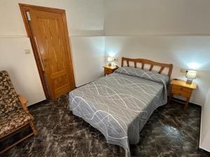 ein Schlafzimmer mit einem Bett, zwei Tischen und einer Tür in der Unterkunft Casa Cele 