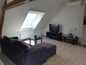 a living room with a couch and a tv at Appartement Kroketje 