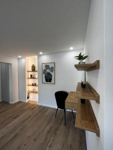 ein Wohnzimmer mit einem Schreibtisch und einem Stuhl in der Unterkunft CentralLuxuryAptHotel in Piatra Neamţ
