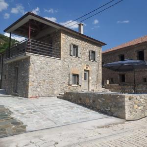 a stone building with an umbrella in front of it at AROANIA suites in Zarouchla