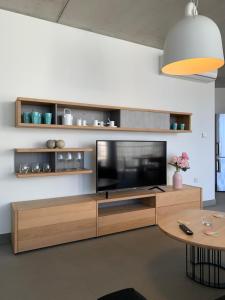 een woonkamer met een televisie op een houten entertainmentcentrum bij Village Point Apartments in Sliema