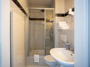 a bathroom with a shower and a toilet and a sink at Hotel Mauritius in Crimmitschau