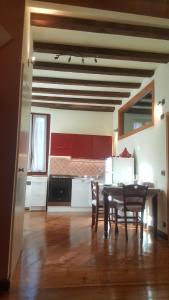 ヴェローナにあるMonolocale in Centro a Veronaのキッチン(テーブル、椅子、赤いキャビネット付)