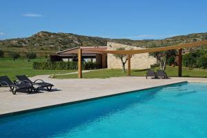 una piscina con sillas y una casa en Hotel El Molí, en Pont de Molins