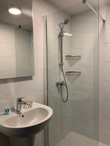 een witte badkamer met douche en wastafel bij Village Point Apartments in Sliema +6 foto's