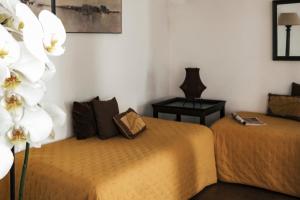 a bedroom with two beds with white flowers in it at Surplage Hotel Cavalière in Le Lavandou