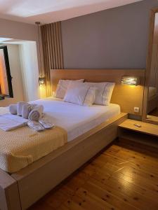 um quarto com uma cama grande e toalhas em Cozy Residences in the center of Volissos Village - Lydia Lithos- em Volissos