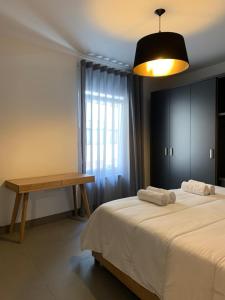 una camera con letto, tavolo e lampada di Village Point Apartments a Sliema