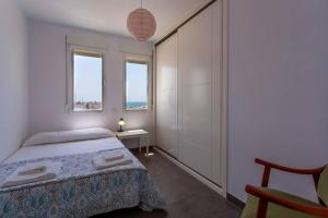 een slaapkamer met een bed, een tafel en 2 ramen bij Cielo gaditano in Cádiz