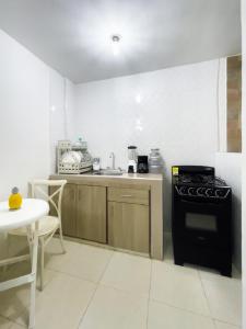 a kitchen with a stove and a sink and a table at 2 bedroom apartment 2CB-3 in Getsemani in Cartagena de Indias
