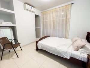 a bedroom with a bed and a chair and a window at 2 bedroom apartment 2CB-3 in Getsemani in Cartagena de Indias