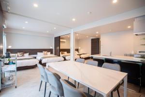 Una habitación de hotel con dos camas y una mesa y sillas. en HOTEL so SUMIYOSHI, en Fukuoka