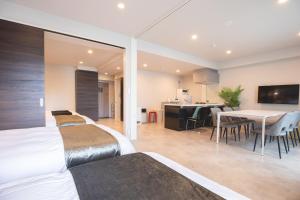 a bedroom with white beds and a dining room at HOTEL so SUMIYOSHI in Fukuoka