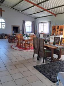 una sala de estar con mesas y sillas de madera. en Cadeau Hiking and Accommodation, en Witelsbos