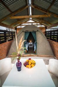Cadeau Hiking and Accommodation في Witelsbos: طاولة في خيمة مع وعاء من الفواكه عليها