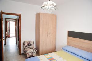 1 dormitorio con 1 cama, armario y silla en Ca l'Armengol, en Balaguer