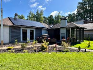 a house with solar panels on the roof at Clockhouse Cottage in Saulkrasti