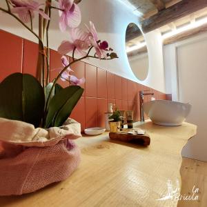 a bathroom with a sink and a vase with flowers on a counter at La Bricola - Sirocco e Garbin in Chioggia +51 photos