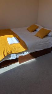 una camera da letto con un grande letto con lenzuola e cuscini gialli di Burton House 