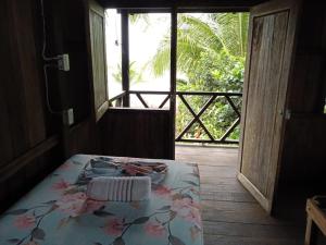 Habitación con cama con mesa y ventana en Casa Colibri, en Nuquí