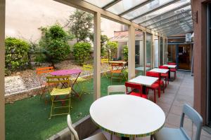 - un ensemble de tables et de chaises sur une terrasse dans l'établissement Adagio Access Lyon Centre Université, à Lyon